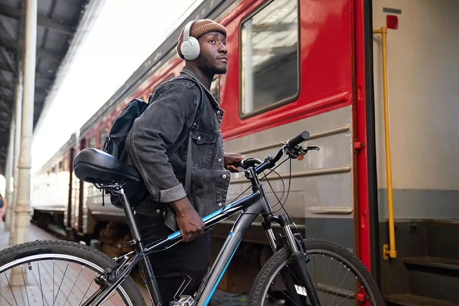 Homem com uma bicicleta e fones JBL Tune 770NC.